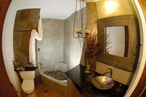 woodland_bathroom_design_stone_shower_pebble_floor_steel_sink_branches_iron_light_fixture_1352849860